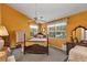 Bright bedroom with an orange accent wall and a beautiful wood framed bed at 2132 Palm Vista Dr, Apopka, FL 32712