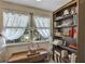 Cozy office featuring shelves filled with books, a wooden desk, and bright windows at 2132 Palm Vista Dr, Apopka, FL 32712
