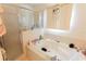 A white tub and tile enclosure with a shower and window providing natural light at 2305 Rio Grande Forest Ln, Kissimmee, FL 34759