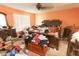 A bedroom with a large bed, window, personal items, and orange walls at 2305 Rio Grande Forest Ln, Kissimmee, FL 34759