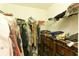 Walk-in closet with shelving and hanging clothes, wood dresser at 2305 Rio Grande Forest Ln, Kissimmee, FL 34759