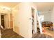 Hallway with wood-look floors, closet, open room with bed, and white walls at 2305 Rio Grande Forest Ln, Kissimmee, FL 34759