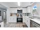 Well-lit kitchen boasts stainless steel appliances, white cabinetry, and a stylish backsplash for a modern touch at 240 Cambridge Blvd, Winter Park, FL 32789