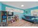 Bright living room with a futon, shelves, and wood-look floors, perfect for relaxing or entertaining at 240 Cambridge Blvd, Winter Park, FL 32789