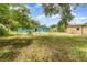 Landscape view of a backyard featuring scattered trees, a shed, and the rear of a building at 240 W Grossenbacher Dr, Apopka, FL 32712