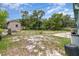 A spacious backyard with a shed, concrete slabs, and mature trees on a partly cloudy day at 240 W Grossenbacher Dr, Apopka, FL 32712