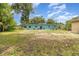 Wide shot of a backyard with a house, shed, trees, and patchy grass at 240 W Grossenbacher Dr, Apopka, FL 32712