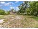 Scenic backyard view with lush trees, a utility shed, and a home under a bright sky at 240 W Grossenbacher Dr, Apopka, FL 32712