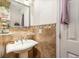 A pedestal sink in a bathroom with tiled walls and a decorative mirror at 240 W Grossenbacher Dr, Apopka, FL 32712