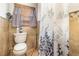 A bathroom featuring a toilet, tiled walls, and a floral shower curtain at 240 W Grossenbacher Dr, Apopka, FL 32712