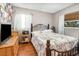 Stylish bedroom boasting a decorative bedframe, hardwood floors, and ample natural light from multiple windows at 240 W Grossenbacher Dr, Apopka, FL 32712