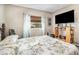 Bright bedroom featuring a decorative bedframe, a mounted TV, and a window offering natural light and views at 240 W Grossenbacher Dr, Apopka, FL 32712