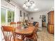 Inviting dining room boasts a wood table, chandelier, and seamless flow into living spaces, perfect for gatherings at 240 W Grossenbacher Dr, Apopka, FL 32712