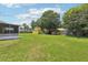 Lush backyard featuring a yellow shed, wooden structure and ample green space at 2704 Yule Tree Dr, Edgewater, FL 32141