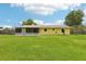 Expansive backyard featuring lush green grass, partial fencing, and a screened-in patio area perfect for outdoor enjoyment at 2704 Yule Tree Dr, Edgewater, FL 32141