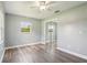 This bright bedroom features new wood floors, ceiling fan, gray walls, and large mirrored closet at 2704 Yule Tree Dr, Edgewater, FL 32141