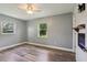 Bright bedroom with gray walls, wood-look floors, ceiling fan and electric fireplace at 2704 Yule Tree Dr, Edgewater, FL 32141