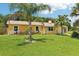 Lovely one-story home with well-manicured lawn and mature palm trees at 2704 Yule Tree Dr, Edgewater, FL 32141