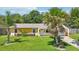 Charming home showcasing a lush front lawn with mature palm trees, complemented by a well-maintained exterior at 2704 Yule Tree Dr, Edgewater, FL 32141