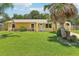 Charming one-story home with a well-maintained lawn and mature palm trees at 2704 Yule Tree Dr, Edgewater, FL 32141
