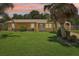 Charming single-story home featuring a lush green lawn and mature palm trees at 2704 Yule Tree Dr, Edgewater, FL 32141