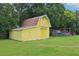 Yellow outbuilding with a barn-style roof, offering additional storage space and a well-maintained exterior at 2704 Yule Tree Dr, Edgewater, FL 32141