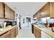 Practical kitchen with wood cabinets, appliances, and connecting laundry room at 2826 Ne 7Th St, Ocala, FL 34470