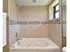 Bathroom features a whirlpool bathtub surrounded by decorative tile, with a window above at 2928 Lake Pineloch Blvd # Ge, Orlando, FL 32806