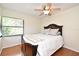 Bedroom with a ceiling fan, wood floors, and a queen-size bed in front of a sunny window at 2928 Lake Pineloch Blvd # Ge, Orlando, FL 32806