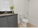 Well-lit bathroom with a dark granite vanity, toilet, and a bathtub with a shower at 3301 Tranquil Trl, Kissimmee, FL 34747
