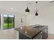 Modern kitchen features a center island, pendant lighting and an open view to the entry and the adjacent lawn at 3301 Tranquil Trl, Kissimmee, FL 34747