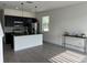 Open-concept kitchen with sleek black cabinets, stainless appliances, and an adjacent living area at 3301 Tranquil Trl, Kissimmee, FL 34747