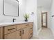 Bright bathroom featuring a wooden vanity, a black framed mirror and tiled shower stall at 388 Hampton Hills Ct, Debary, FL 32713