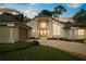 Stunning home exterior featuring a well-manicured lawn, double doors, and architectural pillars at sunset at 388 Hampton Hills Ct, Debary, FL 32713