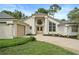 Beautiful home exterior features an attached garage, well-manicured lawn, double doors, and architectural pillars at 388 Hampton Hills Ct, Debary, FL 32713