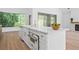 Bright kitchen with white cabinets, stainless steel appliances, and large windows overlooking lush greenery at 388 Hampton Hills Ct, Debary, FL 32713
