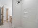 Tiled shower with built-in niche; bathroom features a wooden vanity and glass-enclosed door at 388 Hampton Hills Ct, Debary, FL 32713