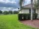 Exterior view showcasing the home's backyard with well-kept lawn and mature trees in the distance at 4034 Bougainvillea Pl, Kissimmee, FL 34746