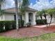 Attractive exterior with a tile roof, manicured bushes and palm trees, plus a brick-lined walkway at 4034 Bougainvillea Pl, Kissimmee, FL 34746