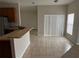 Open floor plan living space with tile floors, natural light and view to kitchen area at 4034 Bougainvillea Pl, Kissimmee, FL 34746