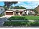 Charming single-story home with a well-manicured lawn, stone accents, and a two-car garage at 414 Bonifay Ave, Orlando, FL 32825