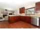 Bright kitchen with stainless steel appliances, granite counters, wood cabinets and view into the living room at 414 Bonifay Ave, Orlando, FL 32825