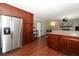 Updated kitchen with stainless steel refrigerator, granite counters, wood cabinets, and view into the living room at 414 Bonifay Ave, Orlando, FL 32825