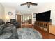 Living room featuring hardwood floors, leather seating, and an entertainment center with a large TV at 414 Bonifay Ave, Orlando, FL 32825