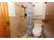 Bathroom shower has tile walls, tile floor, rain shower head, shower curtain and built-in shelves at 414 Bonifay Ave, Orlando, FL 32825