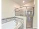 Bathroom showcasing a soaking tub with tile surround and a glass-enclosed shower at 4632 Egg Harbor Dr, Kissimmee, FL 34746