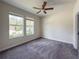 Bright bedroom features plush carpet, ceiling fan, and two windows bringing in natural light at 4632 Egg Harbor Dr, Kissimmee, FL 34746