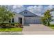 Beautiful two-story home with gray siding, stone accents, and a three-car garage at 4632 Egg Harbor Dr, Kissimmee, FL 34746