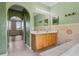Bathroom with a double vanity, tiled backsplash, and an archway leading to a bedroom at 470 Regal Downs Cir, Winter Garden, FL 34787
