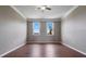 Light-filled bedroom featuring hardwood floors and two large windows providing natural lighting and outdoor views at 470 Regal Downs Cir, Winter Garden, FL 34787
